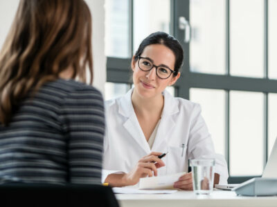 Female physician listening to her patient during consultation Female physician listening to her patient during consultation